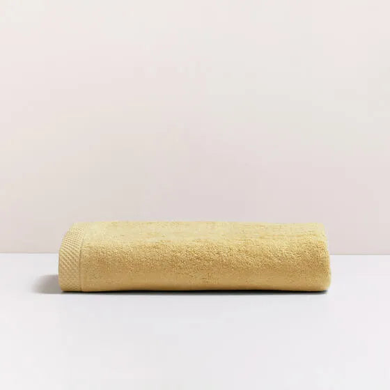 Luxe oker Florence badhanddoek van 100% GOTS-katoen, 600 g/m², hoge kwaliteit, zacht en absorberend.