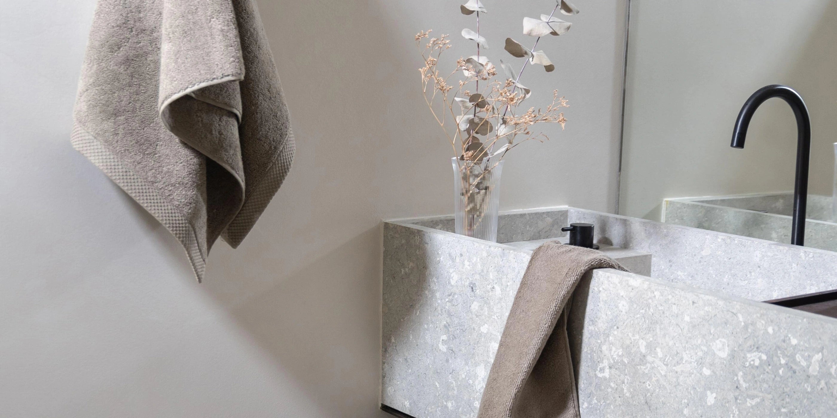 Khaki handdoeken uit de Florence-collectie in een stijlvolle, minimalistische badkamer