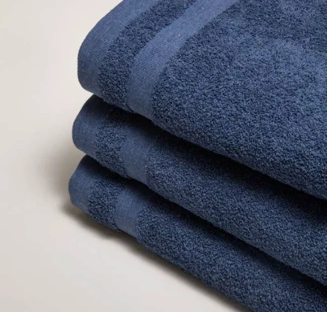 Close-up van drie op elkaar gevouwen luxe Luna-handdoeken in de kleur indigoblauw